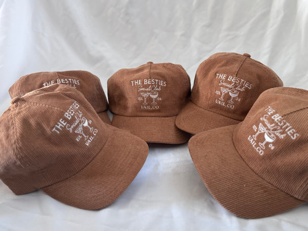 Five rust corduroy hats embroidered with The Besties Social Club, Vail CO, a group order stitched by Threaded by Sal