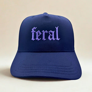 Blue cap with 'feral' embroidered on it against a beige background
