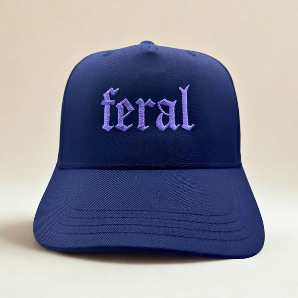 Blue cap with 'feral' embroidered on it against a beige background