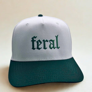 White and green cap with 'feral' text on a beige background