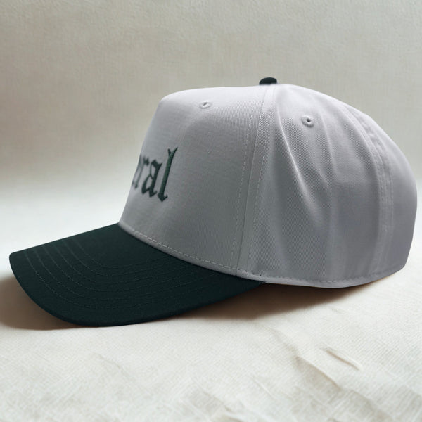 Side view of a white and green cap white 'feral' on a light background